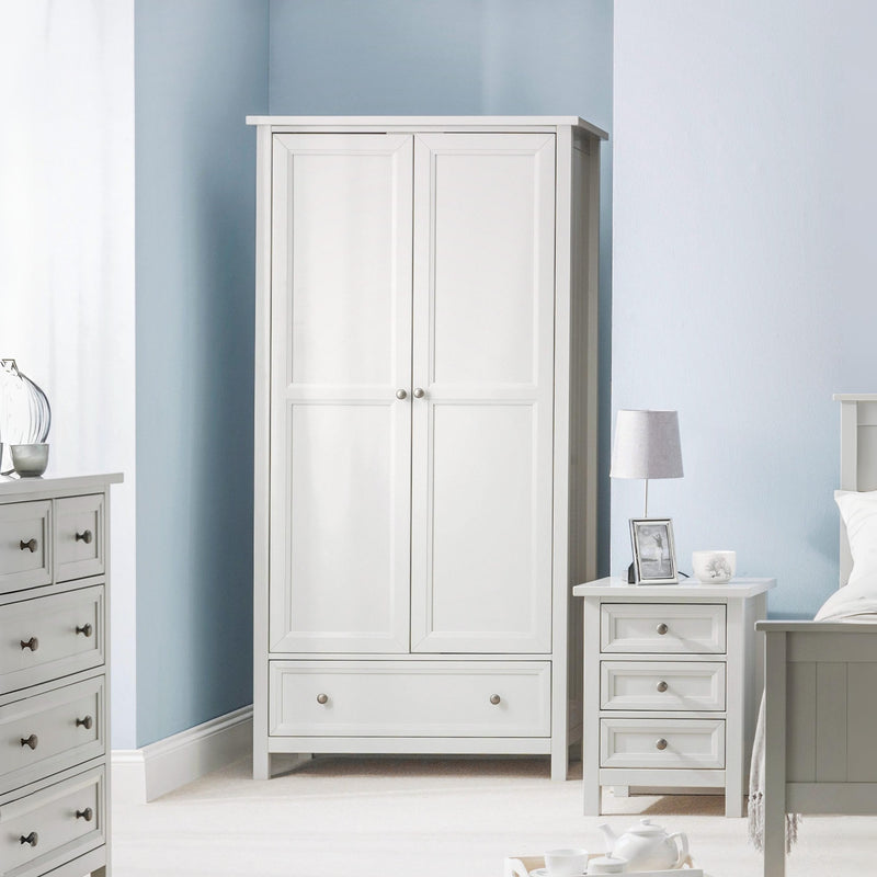 White wardrobe in a bedroom with light blue walls and gray furniture.