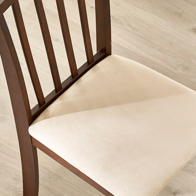 Wooden chair with a beige cushion on a light wooden floor.